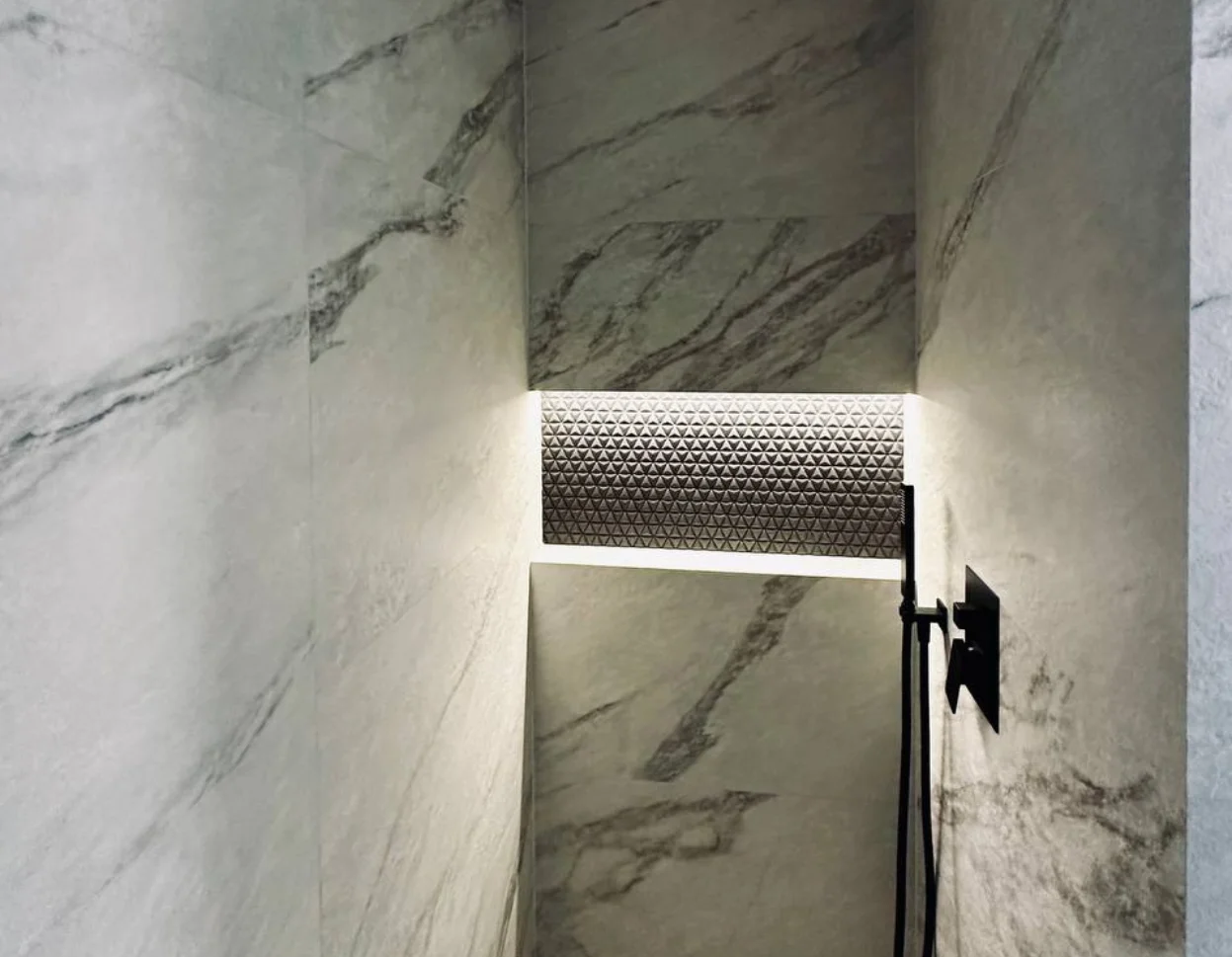 Custom illuminated shower niche with warm LED lighting in Seattle luxury bathroom remodel